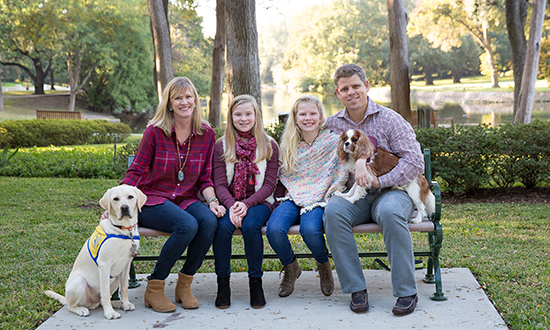 family with small dog and Canine Companions puppy