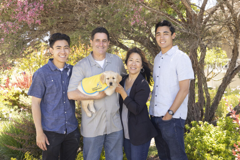 family of four holding canine companions puppy