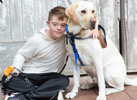 child sitting with Canine Companions service dog