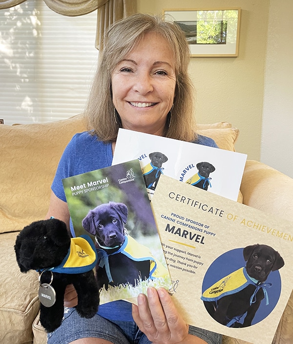 Woman holding the items of the puppy kit and smilling