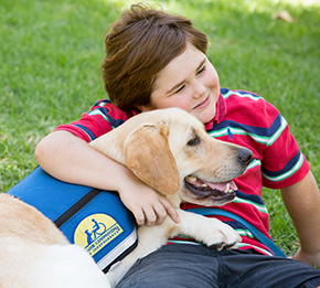 Child hugging Canine Companions puppy