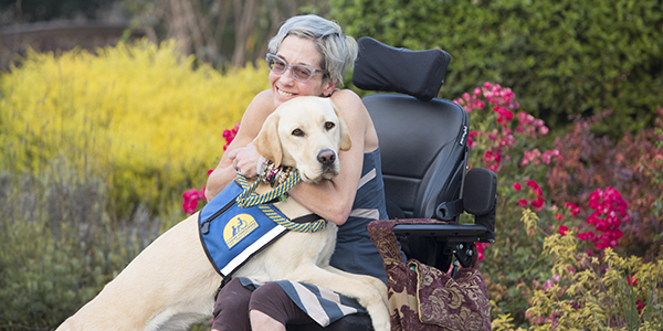 person hugging Canine Companions service dog
